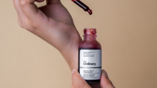 a hand holding a bottle of cranberry syrup