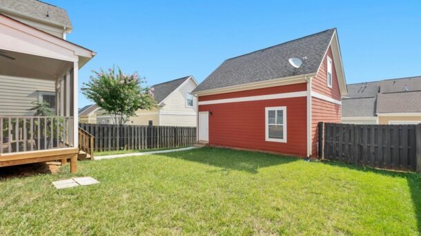 red and white wooden house on green grass field during daytime