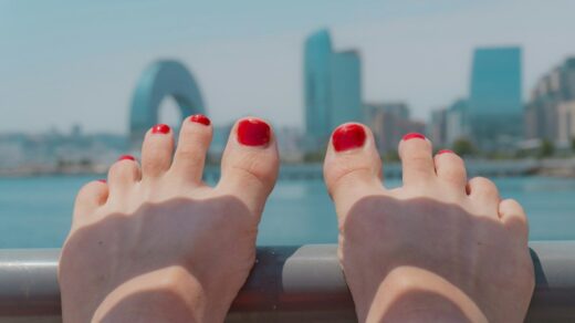 Woman's red painted toenails with cityscape background